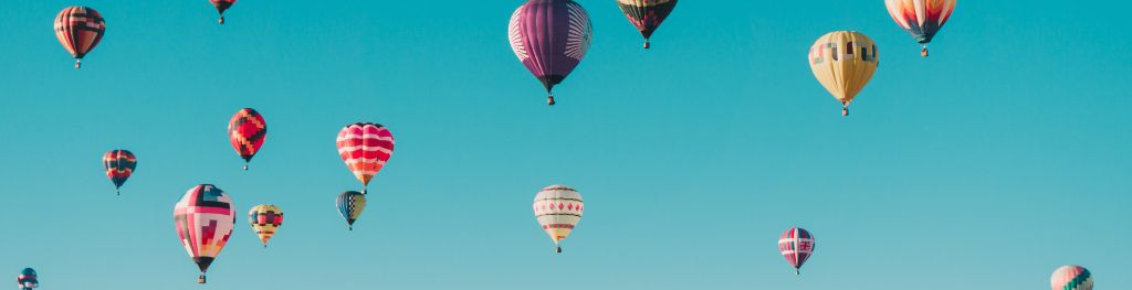 Hot air balloons sailing in a blue sky Photo Ian Dooley
