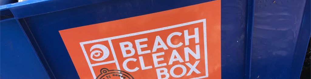 A blue box used for beach cleaning from Surfers Against Sewage with a sticker on the side that reads 'Beach Clean Box'