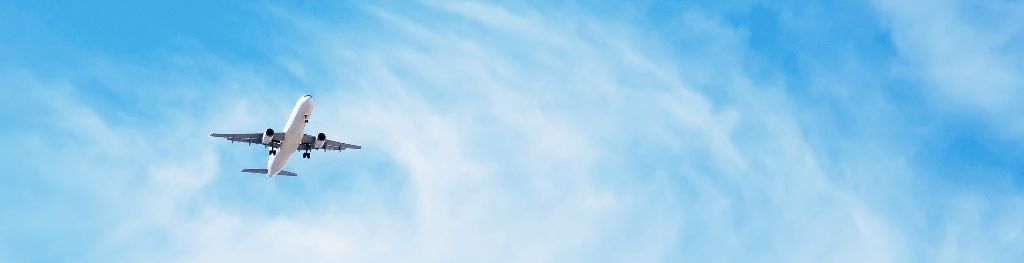 airplane in blue sky with light cloud