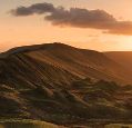 A view over a high green ridge in the evening sun