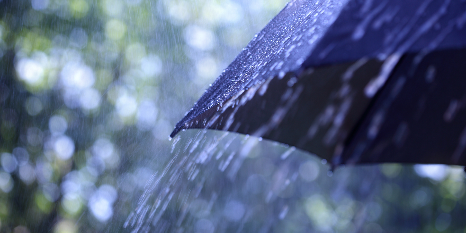 Rain falling on to a black umbrella