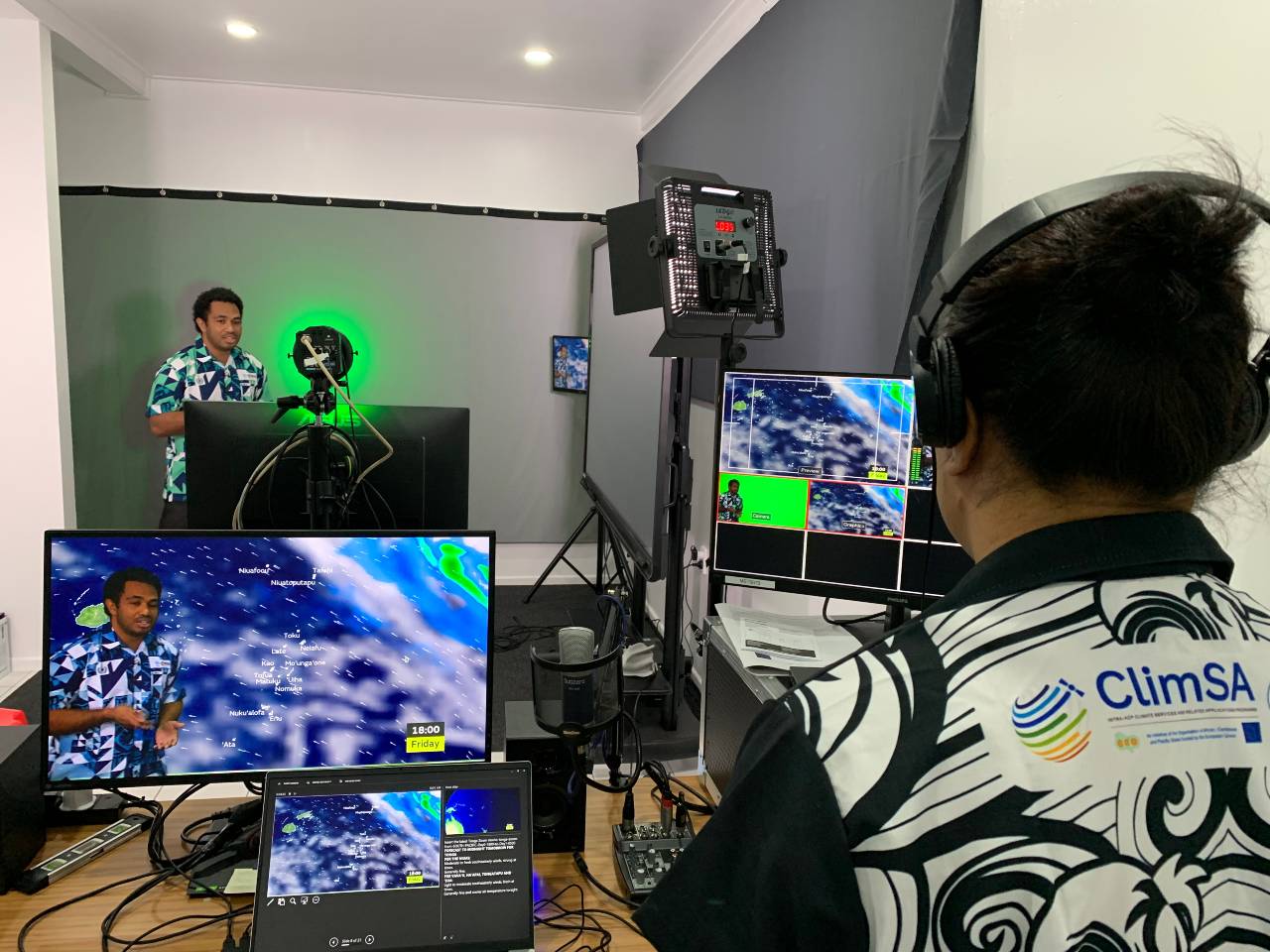 Images of weather presenter in Tonga recording weather in TV studio